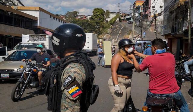 Miembros de las Fuerzas de Acciones Especiales (FAES) patrullan el sector de Petare, verificando que transeúntes usen tapabocas en Venezuela. Foto: EFE