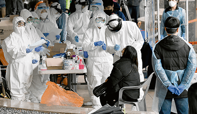 Prueba. Equipo de médicos, muy bien protegido, realiza exámenes minuciosos en centros sanitarios de Seúl. Foto: AFP