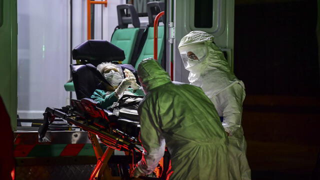 An elderly patient wearing mask and gloves, allegedly infected with the new COVID-19 coronavirus, is taken from a nursing home to an ambulance of the Emergency Medical Care Service (SAME) in the Belgrano neighbourhood of Buenos Aires, Argentina, on April 21, 2020. (Photo by RONALDO SCHEMIDT / AFP)