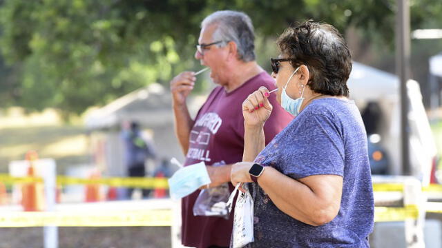 People swab their mouths for the test at a coronavirus testing site in Los Angeles, California on September 4, 2020. - Testing sites for COVID-19 operating in Los Angeles County will close for the Labour Day weekend due to the extreme heat that is forecast to hit southern California. (Photo by Frederic J. BROWN / AFP)