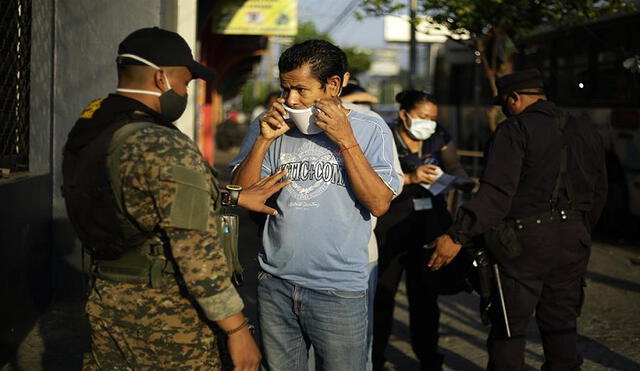 Agentes policiales mantienen un punto de control para personas que deban desplazarse por el centro de San Salvador. Foto: EFE