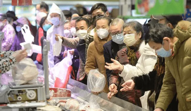 Personas usan máscaras protectoras para comprar en un supermercado en Wuhan, el epicentro del brote de un nuevo coronavirus. Foto: AFP.