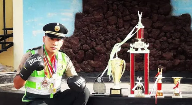 Christian Ticona orgulloso con su uniforme de policía y sus trofeos ganados boxeando