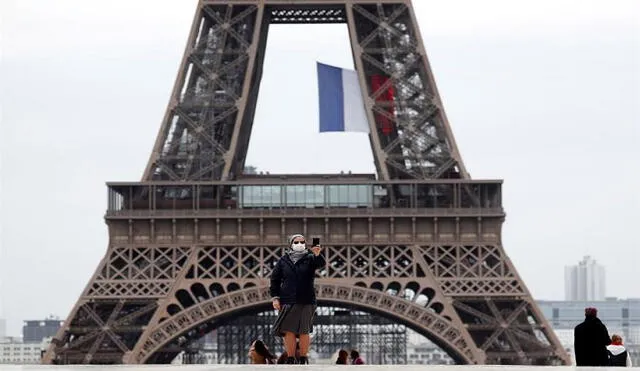 Una monja con mascarilla se toma un 'selfie' este lunes en la plaza del Trocadero, junto a la Torre Eiffel, en París. Foto: EFE