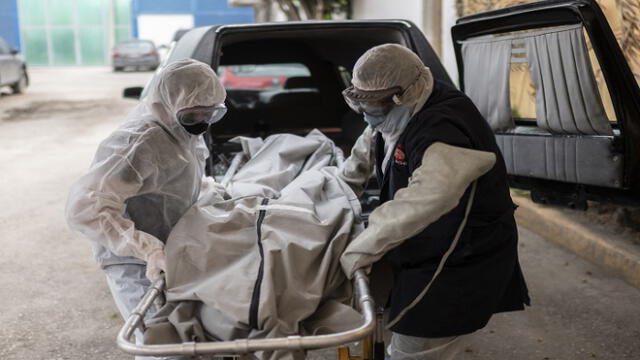 Mortuary workers move the body of a COVID-19 victim at a crematorium in Cuautitlan Izcalli, Mexico State, on April 23, 2020. - By Wednesday, Mexico had registered 10,500 coronavirus cases and just under 1,000 deaths. (Photo by PEDRO PARDO / AFP)