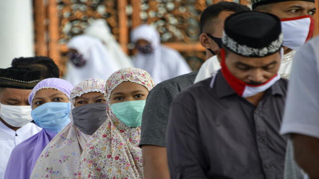 People wearing face masks attend Eid al-Fitr prayers, marking the end of the Muslim holy month of Ramadan, at Baiturrahman grand mosque in Banda Aceh on May 24, 2020. (Photo by CHAIDEER MAHYUDDIN / AFP)
