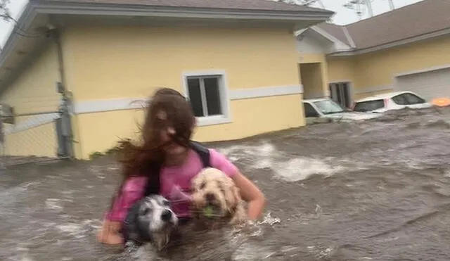 Julia Aylen al rescate de sus dos perros, en plena inundación por el paso del huracán Dorian. Foto: Difusión