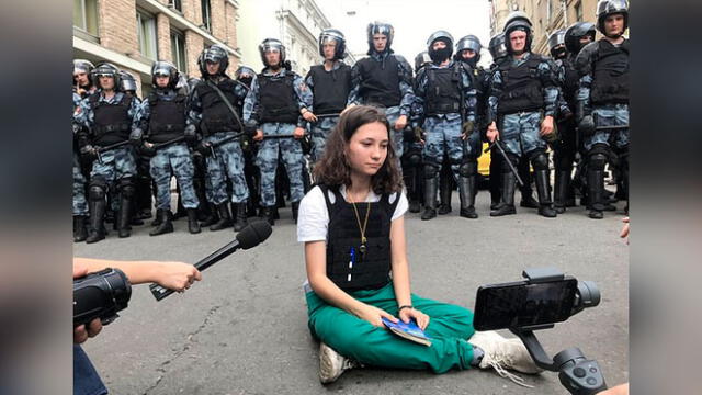 Olga Misik se sienta ante la policía antidisturbios para leer la constitución rusa. Foto: PA.