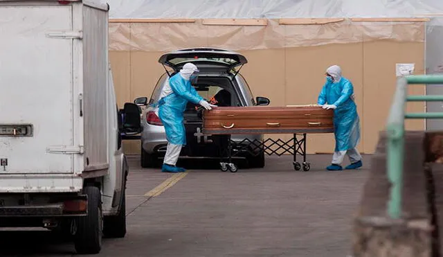 Trabajadores de una funeraria cargan un ataúd en el Hospital San José en Santiago (Chile). Foto: EFE