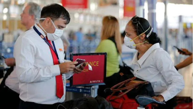 Un miembro del personal del Aeropuerto Internacional Arturo Merino Benítez, en Santiago, usa una máscara protectora como medida preventiva contra la propagación del coronavirus. Foto: AFP.