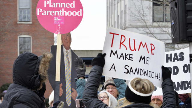 Los asistentes al mitin rodean y bloquean a Diana Ploss, una partidaria del presidente de los Estados Unidos, Donald Trump, durante la Marcha de las Mujeres en Concord, New Hampshire.