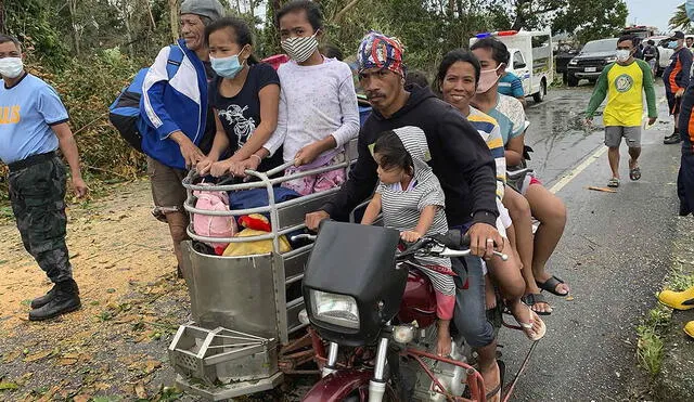 Los residentes viajan en un triciclo de regreso a sus hogares después de que la tormenta tropical Molave el 26 de octubre. Foto: AFP