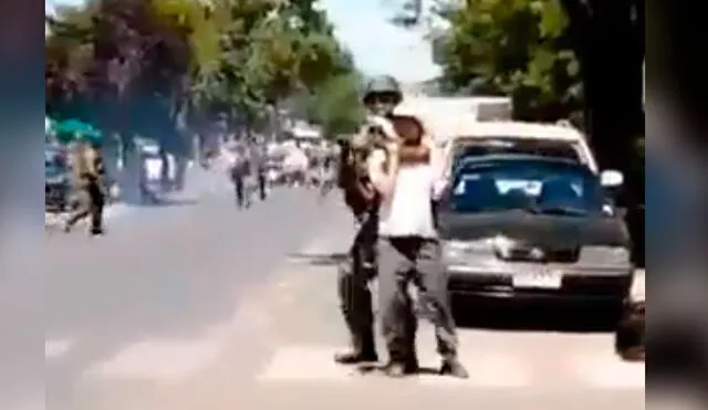 El carabinero usó al presunto menor de 13 años para cubrirse mientras disparaba a los manifestantes. Captura de video.