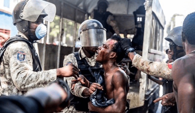 Uno de los manifestantes siendo reprimido violentamente por la Policía de Haití.