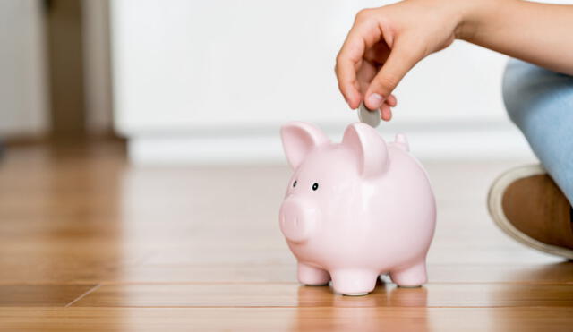 Close up of a boy saving money in a piggybank - home finances concepts