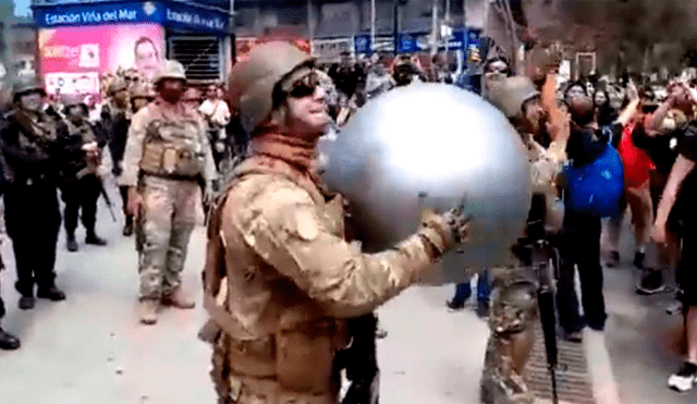 Militares y manifestantes juegan con pelota de playa en plena marcha.