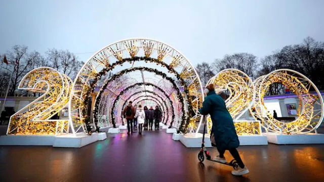 Varias personas pasean por una calle decorada con motivos navideños y con los números 2020 en referencia al nuevo año, instalados en el parque Sokolniki de Moscú (Rusia). EFE/Maxim Shipenkov.