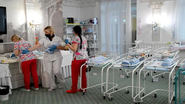 Nurses care for newborn babies at Kiev's Venice hotel on May 15, 2020. - More than 100 babies born to surrogate mothers have been stranded in Ukraine as their foreign parents cannot collect them due to border closures imposed during the coronavirus pandemic, authorities said on May 14. (Photo by Sergei SUPINSKY / AFP)
