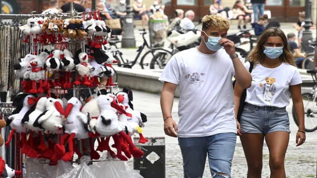 People wearing face masks pass by a gift shop on May 22, 2020 in Strasbourg, eastern France, after the city of Strasbourg on May 20, issued a decree making the wearing of masks "obligatory" in the city centre at the busiest hours of the day. (Photo by FREDERICK FLORIN / AFP)