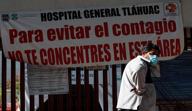Un hombre frente a un letrero de advertencia de alto contagio de la COVID-19 en el Hospital General Tláhuac de Ciudad de México. Foto: EFE