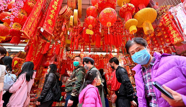 La gente compra en un mercado que ofrece decoraciones y golosinas del Año Nuevo Lunar en Hong Kong el 17 de enero de 2021. Foto: AFP