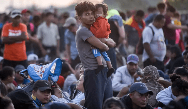 Miembros de la caravana migrante esperan sobre el puente internacional que divide México y Honduras, con la esperanza de lograr cruzar la frontera entre estas dos naciones. Foto: AFP