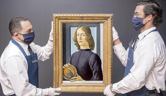 Pintura. Personal de la casa de Sotheby’s de Nueva York sostiene ‘Hombre joven sujetando un medallón’, de Botticelli. Foto: difusión