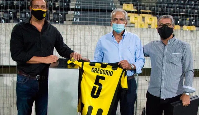 Gregorio Pérez, exDT de Universitario, recibió una distinción por parte de Pablo Bengoechea, actual director deportivo de Peñarol. Foto: Peñarol/Twitter
