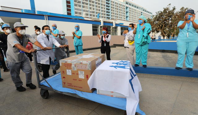Un médico ayuda a personal de Cenares a empujar cargamento hasta almacenes del hospital Rebagliati. Foto: EsSalud