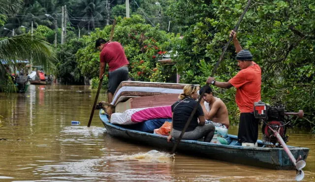 Familias intentan salvar sus pertenencias subiéndose a pequeñas embarcaciones. Foto: Paolo Peña