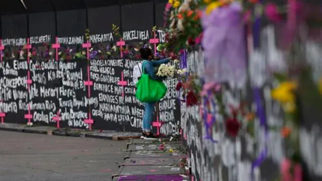Las mujeres colocaron flores y carteles con nombres de víctimas por feminicidios en los cercos metálicos instalados por el Gobierno capitalino. Foto: AFP