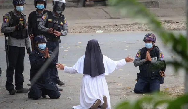 Mientras la monja suplica, otro grupo de policías arremete contra los manifestantes. Foto: AFP