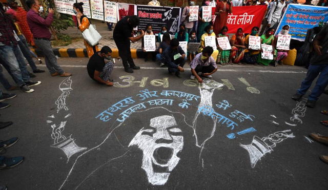 Manifestantes en India pintan un mural en el piso mientras protestan contra la violación en grupo y el asesinato de una mujer de 19 años. Foto: AFP
