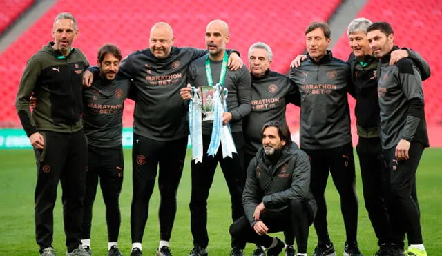 El director técnico español posando con sus colaboradores tras conseguir la Copa de la Liga con el Manchester City. Foto: AFP