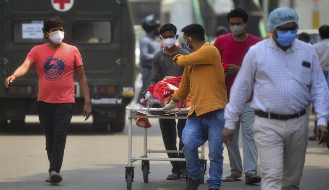 Los miembros de la familia llevan a un pariente con COVID-19 a un hospital en India. Foto: AFP