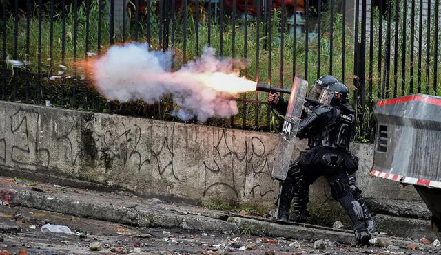 Policías disparan bomba lacrimógena contra manifestantes en Cali, el lunes 10 de mayo. Foto: AFP