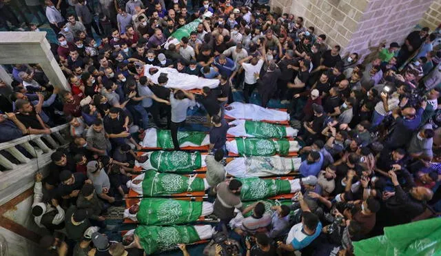 Los palestinos se reúnen para rezar alrededor de los cuerpos de 13 militantes de Hamas, muertos en ataques aéreos israelíes sobre Gaza. Foto: AFP