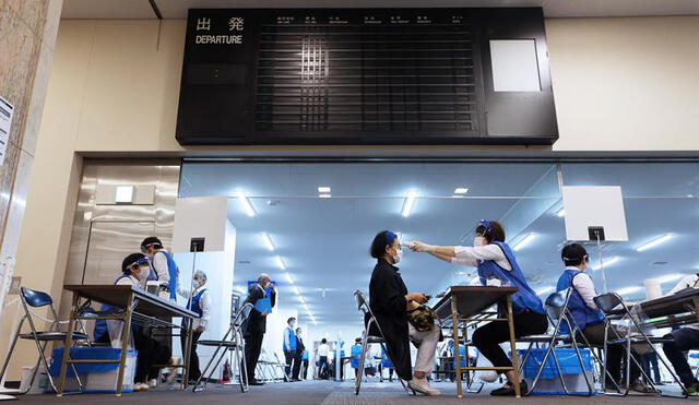 A una mujer le controlan la temperatura corporal en un centro de vacunación COVID-19 instalado dentro del aeropuerto de Nagoya, en el centro de Japón, el 24 de mayo de 2021. Foto: EFE