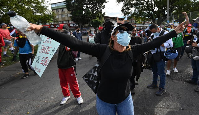 Manifestantes en Cali (Colombia) gritan consignas a policías durante una nueva protesta contra el Gobierno de Duque. Foto: AFP