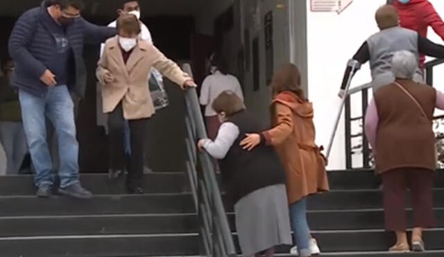 Adultos mayores reciben ayuda para subir escaleras en Universidad Alas Peruanas. Foto: captura de América TV
