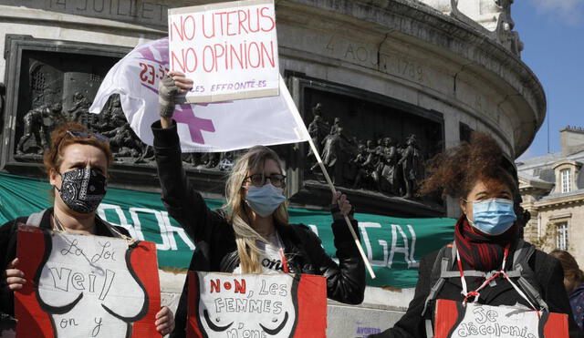 Miembros de la asociación feminista "Les Effronte-E-S" sostienen carteles con dibujos de cuerpos de mujeres durante un encuentro para defender el derecho al aborto en París. Foto: AFP