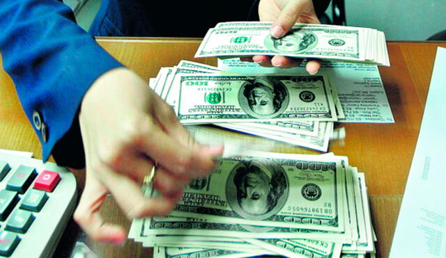 El precio del dólar oficial es chequeado tanto por compradores como por comerciantes. Foto: AFP