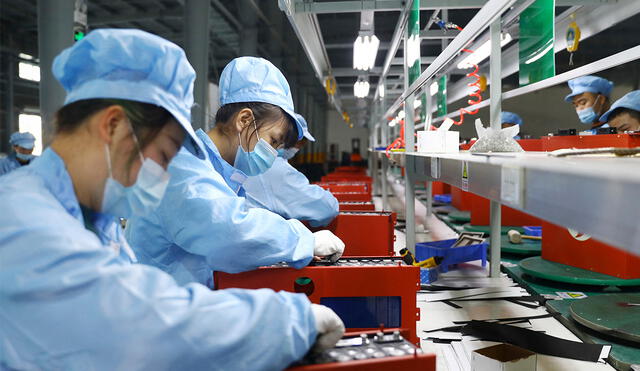 Esta foto tomada el 14 de noviembre de 2020 muestra a empleados que trabajan en el taller de una empresa de fabricación de baterías de litio en Huaibei, provincia de Anhui, en el este de China. Foto: AFP