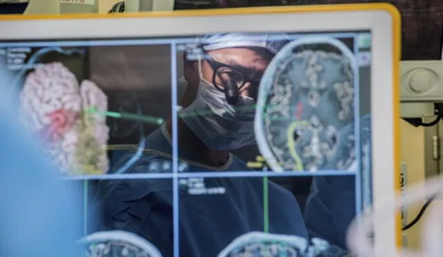 El neurocirujano Edward Chang, líder del desarrollo del dispositivo, viendo el monitor de una computadora que muestra escáneres cerebrales. Foto: AP