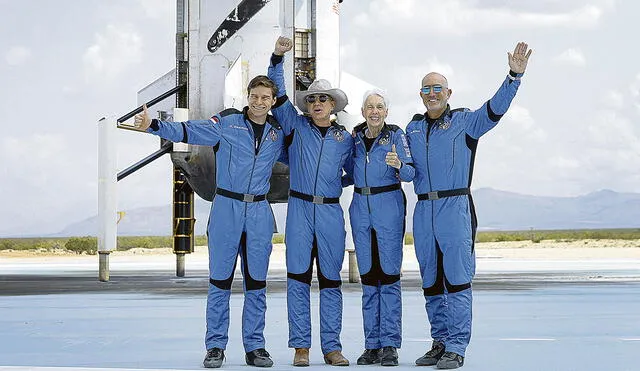 Felices. Tripulación del New Shepard, conformada por Oliver Daemen, Jeff Bezos, Wally Funk y Mark Bezos, posa para una foto cerca del propulsor después de volar al espacio. Foto: AFP