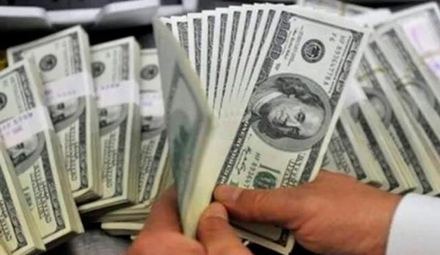 El precio del dólar oficial es revisado tanto por compradores como por comerciantes. Foto: AFP