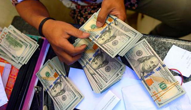 El precio del dólar oficial es chequeado tanto por compradores como por comerciantes. Foto: AFP
