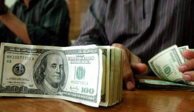 El precio del dólar oficial es revisado tanto por compradores como por comerciantes en Venezuela. Foto: AFP