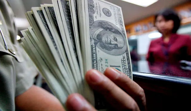 El precio del dólar oficial es revisado tanto por compradores como por comerciantes en Venezuela. Foto: EFE