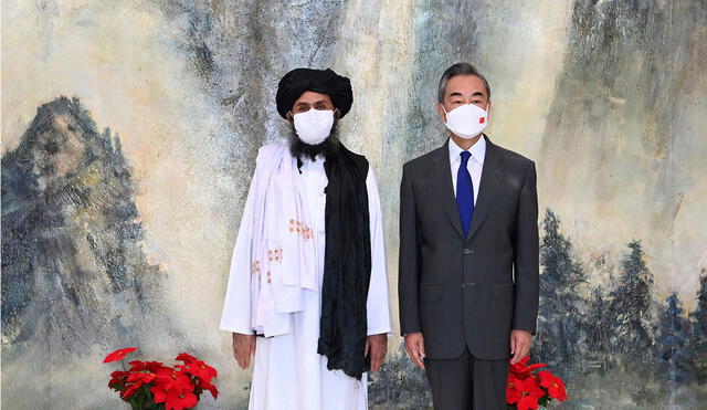 Abdul Ghani Baradar, líder político del movimiento talibán, y Wang Yi, ministro de Exteriores chino, luego de reunión en julio de este año. Foto: AP
